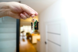 Holding house keys in front of the entrance.